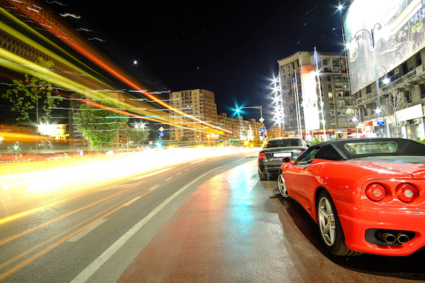 Speed Concept -- Red Sports Car in Night Traffic Lights